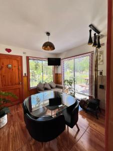 ein Wohnzimmer mit einem Glastisch und einem Sofa in der Unterkunft Cabaña estilo mediterránea in Pucón