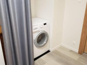 a washer and dryer in a room with a curtain at Maison de Montagne à La Bresse, 2 Chambres, Confort et Activités, Garage, Wifi Inclus - FR-1-589-152 in La Bresse