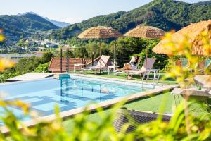 a woman sitting in a chair next to a swimming pool at Gapyeong Bobo Dog Pool Villa in Gapyeong