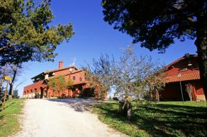 a dirt road in front of a red building at Tenuta Merlano in Sacrofano