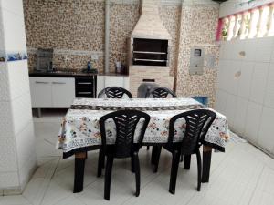 cocina con mesa con 4 sillas y cocina en Pink house Enseada Beach, en Guarujá