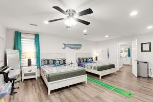 a bedroom with two beds and a ceiling fan at Ocean - 5 Beds Retreat with Pickleball, Arcade, Grill & Beach Access! in Fort Walton Beach