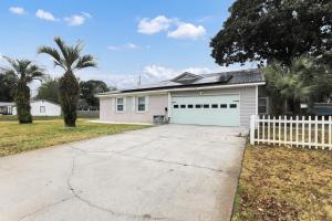 a white house with a white fence and a driveway at Ocean - 5 Beds Retreat with Pickleball, Arcade, Grill & Beach Access! in Fort Walton Beach