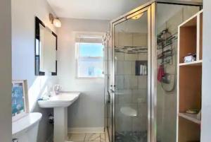 a bathroom with a shower and a sink at A Drunken Parrots Beach Side Paradise in North Topsail Beach +63 photos