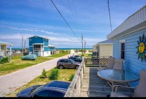 a deck with a table and chairs on a house at A Drunken Parrots Beach Side Paradise in North Topsail Beach