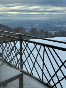 a snow covered balcony with a bench in the snow at Grand Elegant & SPA in Kopaonik