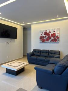 un salon avec un canapé bleu et une télévision dans l'établissement Casa Privada Acapulco, à Acapulco