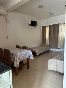 a room with two beds and a table and a television at Luna de Cuarzo in Cafayate +34 photos