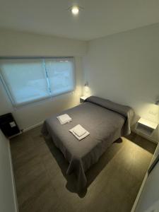 a bedroom with a bed with two towels on it at NUEVO Departamento de 3 ambientes 2 habitaciones-cocina-living comedor-baño-balcon in Mar del Plata