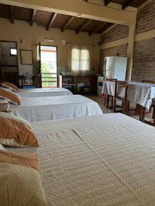 a bedroom with two beds and a kitchen with a table at Luna y Cumbres in Cafayate