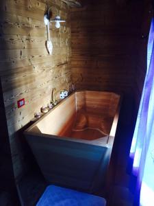 bañera de madera en una habitación con pared de madera en Chalet Lagorai, en Roncegno
