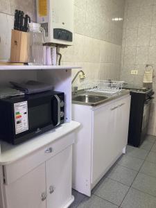 a kitchen with a microwave and a sink at Casa Relmu in Puerto Varas +2 photos