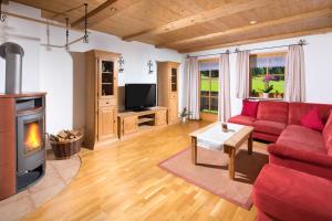 Una sala de estar con un sofá rojo y una chimenea. en Braunlehen Walch, en Berchtesgaden