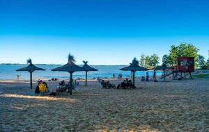 a beach with chairs and umbrellas and the ocean at Alojamiento Las Camelias in Concordia