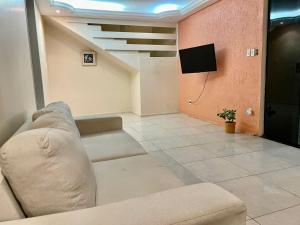 a living room with a couch and a flat screen tv at Green House in Aracaju