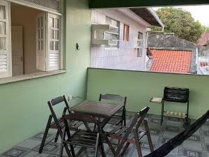 a table and chairs on a patio with a house at Green House in Aracaju