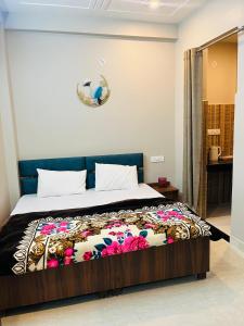 a bedroom with a bed with a colorful blanket on it at Vedshree in Prayagraj +16 photos