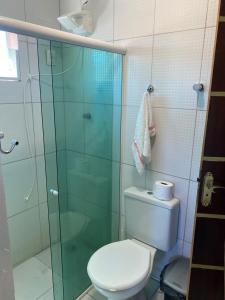 a bathroom with a toilet and a glass shower at Residência Naiote in Japaratinga +24 photos