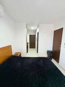 a bedroom with a bed with a black bedspread at Fantástico Depa en Cerritos OCEANNA frente al MAR ! - 237 AB - in Mazatlán +37 photos