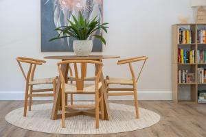 a wooden table with two chairs and a potted plant at Billie's on Smiths in Smiths Lake +20 photos