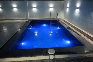 a swimming pool with blue lights in a room at Your Place - The Pool Villa in Roorkee