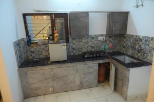 a small kitchen with a sink and a refrigerator at Your Place - The Pool Villa in Roorkee