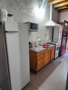 a kitchen with a white refrigerator and a stove at Cabañas El Rosedal in San Rafael