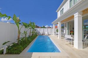 a swimming pool in the backyard of a house at Seaside Cottage Sumuide in Nago