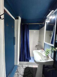 a bathroom with a blue shower curtain and a sink at Cabaña Luna Rubia in La Pedrera +33 photos