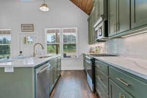 a kitchen with green cabinets and a sink at The June Hot tub with king beds on 2 acres in Hot Springs +24 photos