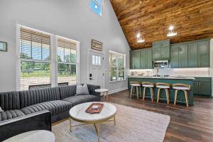a living room with a couch and a kitchen at The June Hot tub with king beds on 2 acres in Hot Springs