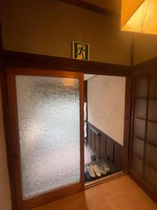 a room with a glass door and a pair of shoes at 懐かしい日本の家 nostalgic Japanese house For-R Uwamachi Share House in Yokosuka