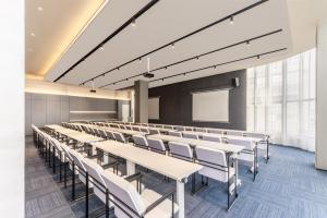 una sala conferenze con tavoli, sedie e schermo di Atour Light Hotel Xuzhou Tongshan Wanda Plaza a Xuzhou