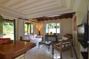 a living room with a couch and a tv at Pousada Dos Búzios in Búzios