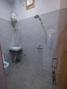 um banheiro com chuveiro e vaso sanitário em The Rose Bagh Resort Pushkar em Pushkar