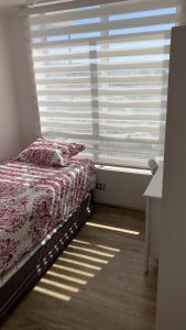 ein Schlafzimmer mit einem Bett vor einem Fenster in der Unterkunft Nuevo y Bello Departamento Cerro Placeres Valparaíso Vista al Mar in Viña del Mar + 17 Fotos