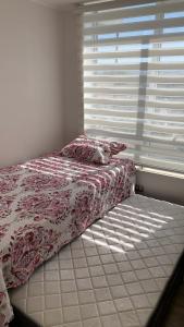 ein unverbautes Bett in einem Schlafzimmer mit einem Fenster in der Unterkunft Nuevo y Bello Departamento Cerro Placeres Valparaíso Vista al Mar in Viña del Mar