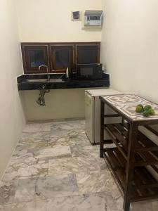 a kitchen with a counter and a sink and a table at Baan Yanikar in Lampang