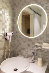 uma casa de banho com um lavatório branco e um espelho. em Summer View Hotel em Singapura