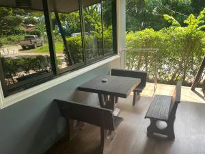 a table and benches in a room with a window at Modern 2-Bedroom Villas with Pool Access in Krabi town +3 photos