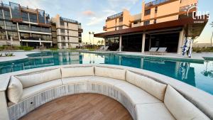 a pool with a couch in front of a building at Cais Eco Resort in Porto De Galinhas