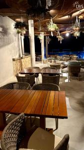 a restaurant with wooden tables and chairs and lights at Cais Eco Resort in Porto De Galinhas