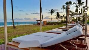 a bed on a deck next to the beach at Cais Eco Resort in Porto De Galinhas