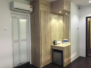 een kamer met een houten muur met een kleine tafel en verwarming bij The Oikos Hotel in Pontian Kecil