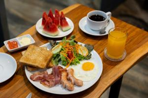 a table with two plates of breakfast food and a cup of coffee at Nature Boutique Hotel Ratchayothin in Bangkok