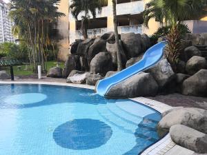 a blue slide in a swimming pool with rocks at Venice Hill Cheras SunriseCorner in Cheras
