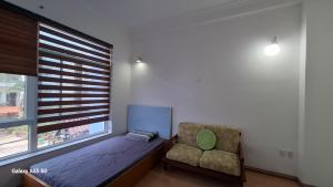 Shanti-blissed corner of Saigon river's end في مدينة هوشي منه: غرفة نوم بها سرير وكرسي ونافذة