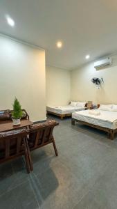 a room with two beds and a table in it at Vĩnh Hy House in Ninh Hải