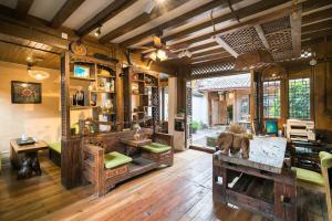 麗江市にあるBig Tree Guesthouse - Naxi old styleのリビングルーム(ウッドフロア)、家具付きの部屋