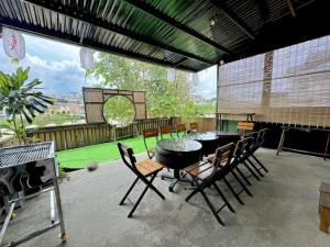 a patio with a table and chairs and a large window at SAKURA House ĐÀ LẠT in Da Lat